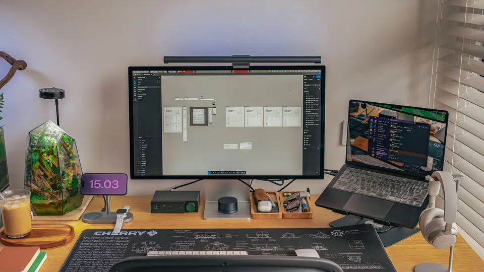 Dual screen workstation showing analytics, sleek keyboard, and modern coffee mug
