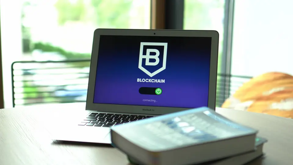 Physical cryptocurrency coin hardware cold-storage wallet illuminated beside ledger