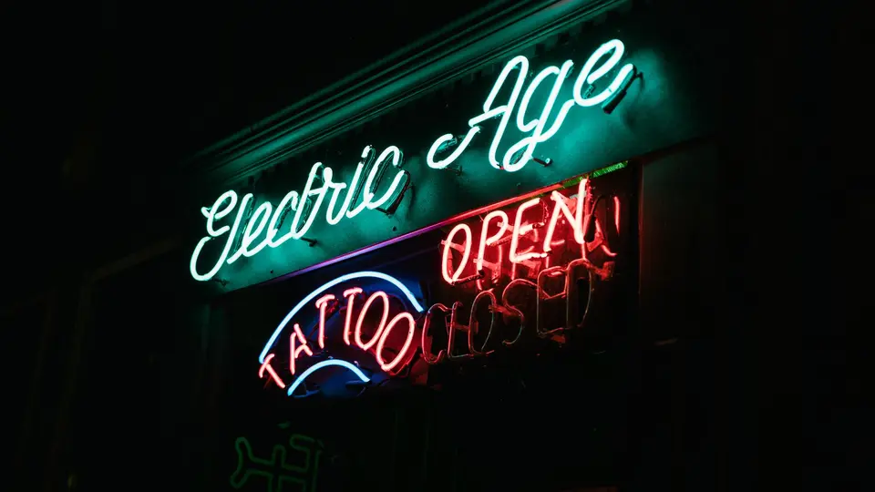 Modern crowded luxury shopping mall with neon branding and consumer displays