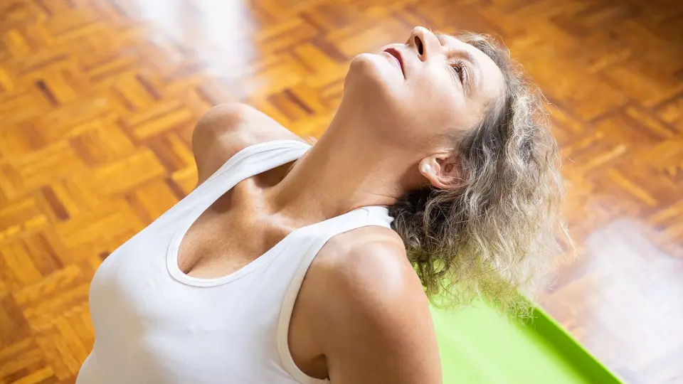Person sitting cross-legged in silent meditation inside sunlit room free of screens